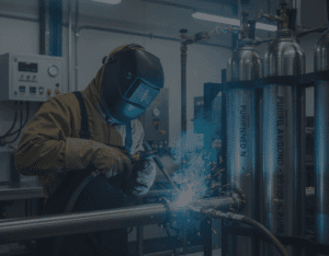 Highly-skilled technician performing TIG welding on stainless steel piping using purified 99.999% argon gas from high-purity cylinders in a controlled industrial environment.